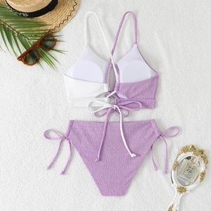 Detailed view of two-piece bikini featuring textured fabric with criss-cross tie straps
