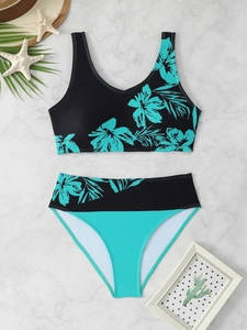 Flat lay of tropical floral print bikini set with high-waisted bottoms on marble surface