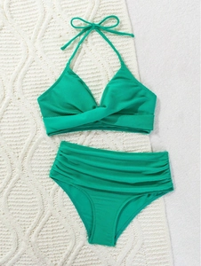 Detail of neon green ribbed bikini showing crossover twist knot and high waist texture