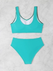 Flat lay of teal two-piece bikini featuring high waist bottom and top with removable pads