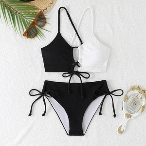 Detail of color-block bikini set with textured fabric, cross tie top, and side-tie bottoms