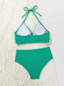Detail of emerald green ribbed bikini set showing fabric texture and halter neck tie