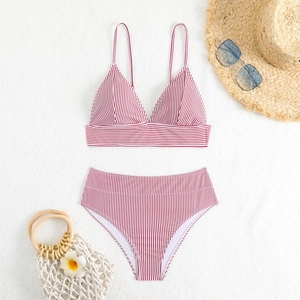 Flat lay of red and white striped high-waisted bikini with summer beach accessories