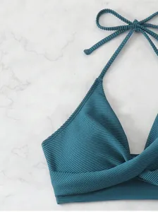 Detailed view of the turquoise ribbed knit bikini top with cross knot front and halter ties