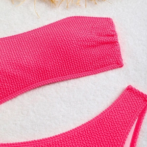 Detail of rose pink bikini featuring textured smocked fabric and bandeau top design