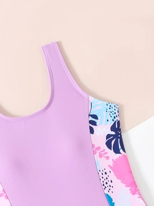 Dettaglio costume da bagno lilla per bambina con stampe tropicali e cuciture rifinite