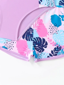 Dettaglio dei pantaloncini da nuoto per bambina con stampa tropicale e tessuto elastico