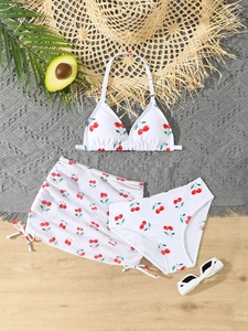 Flat lay of a girls three-piece bikini set with vibrant cherry print and mesh skirt