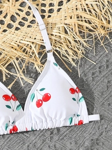 Detail of cherry print bikini top with adjustable straps and ruffled edges