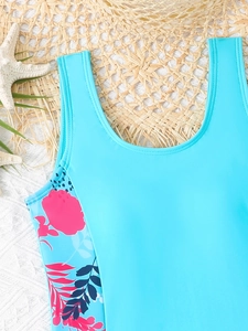 Dettaglio costume da bagno celeste con fiori rosa e accessori da spiaggia estiva