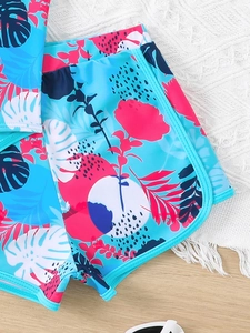 Dettaglio in piano dei pantaloncini da bagno per bambina con stampa tropicale blu