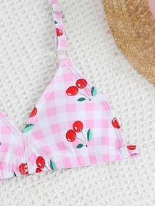 Detail of pink gingham bikini top with cherry print and adjustable shoulder straps