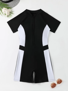 Detail showing high-neck zipper closure and black-white contrast panels on swimsuit