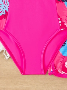 Dettaglio del costume da bagno rosa per bambina con cuciture piatte e stampa tropicale
