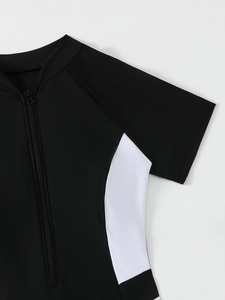 Detail of the half-zipper front and contrast white stitching on a black surf swimsuit