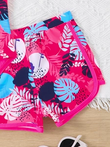 Dettaglio dei pantaloncini da bagno per bambina con stampe tropicali di monstera