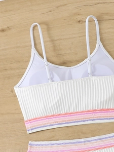 Dettaglio del top bikini bianco a coste con elastici colorati e spalline regolabili