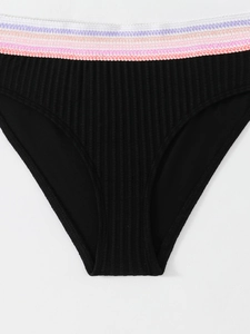 Dettaglio del tessuto a costine nero e della fascia elastica a righe colorate del bikini