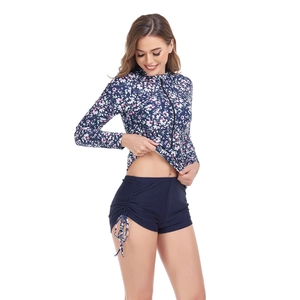 Detail of floral long sleeve swimsuit with zipper front and high waisted drawstring shorts