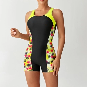 Detail of athletic one-piece swimsuit with palm tree prints and neon yellow piping accents