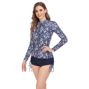 Detail of floral print long sleeve rash guard with zipper and drawstring swim shorts
