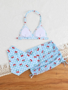 Close-up of girls' three-piece gingham swimwear with cherry print and drawstring skirt