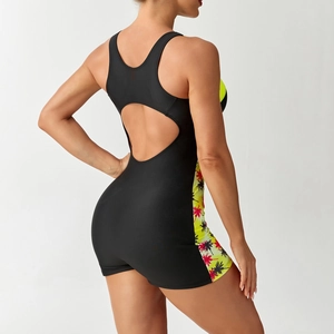Detail of racerback cutout and tropical palm print on a one-piece athletic swimsuit