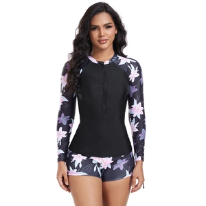 Front view of women's two-piece swimsuit with long sleeves and floral print on white background