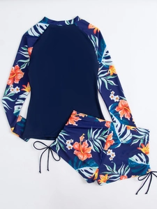 Détail de l'imprimé floral tropical sur le maillot de bain deux pièces à manches longues et cordon