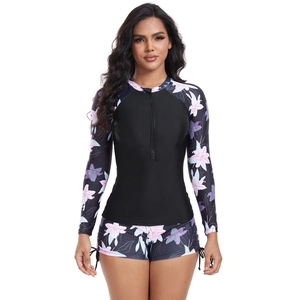 Detail view of long sleeve floral swimsuit set featuring a front zipper and side drawstrings