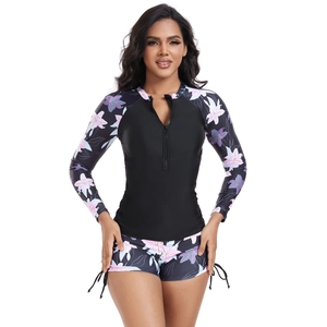 Detail of long sleeve surfboard zipper top with purple lily floral print on sleeves