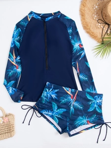 Détail d'un ensemble rashguard à manches longues avec imprimé tropical et short à cordon