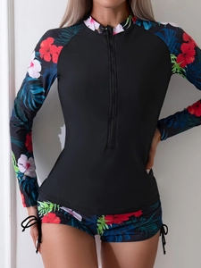 Détail du haut de bikini à manches longues avec imprimé floral tropical et zip frontal