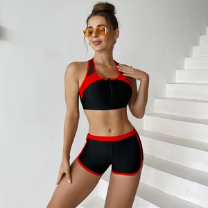 Detail of two-piece athletic bikini with front zipper and red trim on black mesh