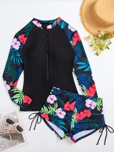 Mise à plat d'un ensemble rashguard floral à manches longues avec short à cordon et accessoires