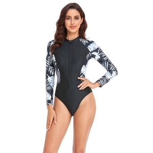 Close-up of long sleeve one-piece swimsuit featuring tropical palm leaf print and front zipper
