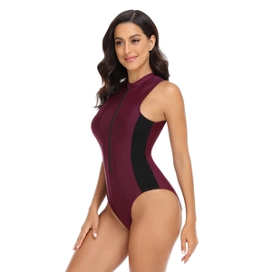 Detail of burgundy one-piece swimsuit featuring black side panels and front zipper closure