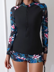 Détail du maillot de bain à manches longues avec imprimé tropical et zip frontal