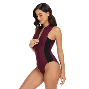 Detail of burgundy one-piece swimsuit with black mesh panels and front zipper closure