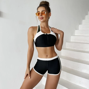 Women's two-piece athletic swimwear with black and white zipper top and high waisted shorts