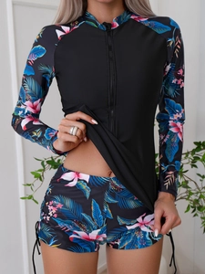 Détail du maillot de bain manches longues avec imprimé tropical et zip frontal