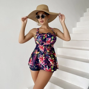 Floral print tankini with drawstring bust and navy boyshorts on a beach model