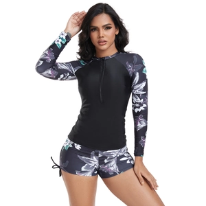 Detail of long sleeve floral surfing swimsuit featuring zipper front and drawstring shorts