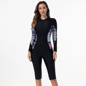 Détail d'un maillot de bain manches longues noir avec des motifs géométriques colorés