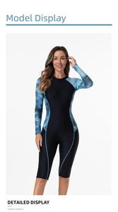 Close-up of women's long-sleeve surfing suit featuring black body and teal side patterns