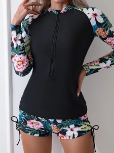 Détail du maillot de bain manches longues à fleurs tropicales avec zip frontal