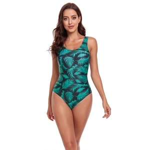 Detail of black one-piece swimsuit featuring green palm leaf print and high-cut leg