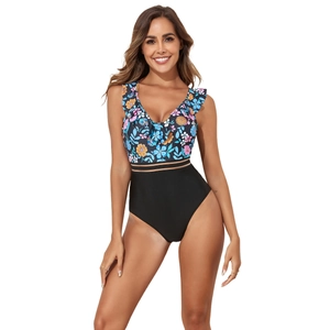 Detail showing floral print, ruffled V-neckline and waist cutout on one-piece swimsuit