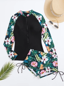 Vue à plat d'un rashguard floral à manches longues et d'un short de bain à cordon de serrage