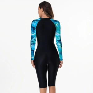 Detail of long sleeve surfboard swimsuit featuring blue marble print and black fabric